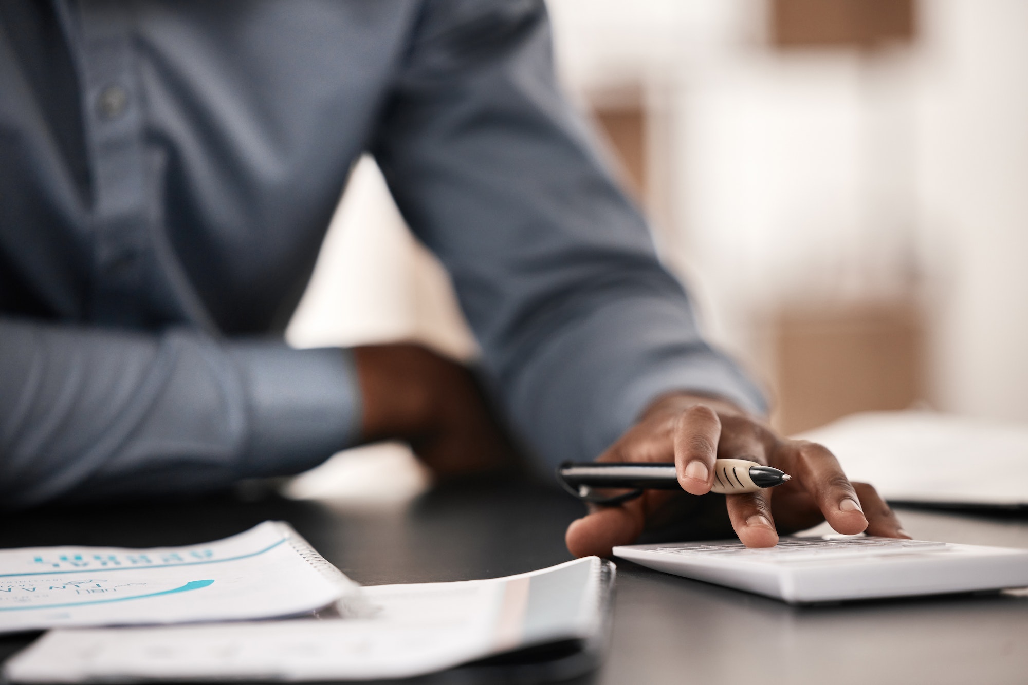 Accountant, financial planning and bookkeeping man using calculator and paperwork to budget, payrol